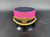 pink and black hat with gold trim on top of a black table
