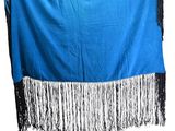 a blue and black blanket with fringes hanging from it