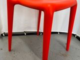 une image représentant une chaise en plastique rouge dans une pièce