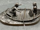 deux figurines représentant un homme et une femme dans un bateau