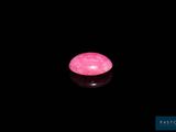 une bougie rose allumée dans l'obscurité
