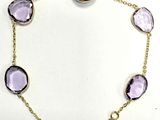 un gros plan d'un bracelet orné de pierres violettes