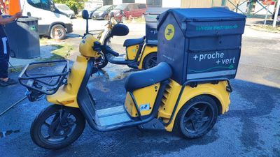 a yellow scooter with a box on the back of it