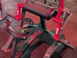 a red and black bench in a gym with other equipment
