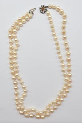 un collier de perles à un rang avec un fermoir en argent