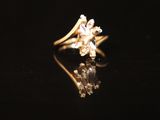 a close up of a diamond ring sitting on top of a black surface
