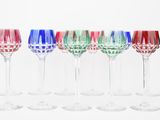six wine glasses are lined up in a row on a white surface
