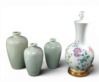 quatre vases posés les uns à côté des autres sur une surface blanche