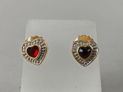 a pair of heart shaped earrings with red and white stones