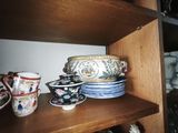 many cups and saucers on a shelf in the kitchen