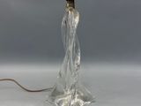 une photo d'une lampe en verre transparent posée sur une surface blanche