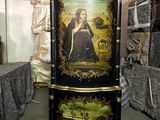 a black cabinet with a painting on it in a room