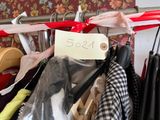 a bunch of clothes hanging on a rack with a price tag