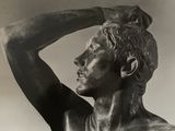 photographie en noir et blanc représentant la statue d'un homme, les mains sur la tête