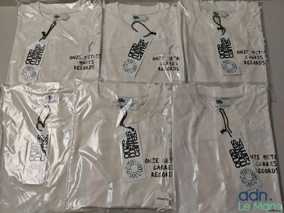 six t-shirts blancs avec des motifs en noir et blanc, posés sur une table