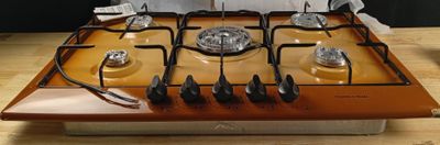 une plaque de cuisson orange équipée de quatre feux