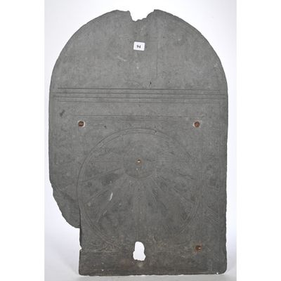 a grey stone plaque with a circular design on it
