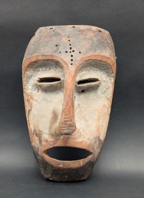 une image représentant un masque en argile sur fond noir