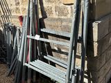 a pile of metal pipes leaning against a stone wall