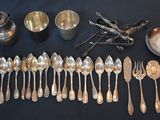 a group of silver spoons and silverware on a table