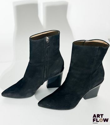 paire de bottines noires en daim avec des fermetures éclair sur le côté