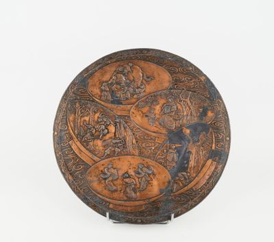 an old metal plate with a design of people and animals on it