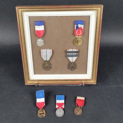 three medals are displayed in a shadow box on a black background