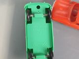 a green toy car and a orange toy car on a table