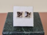 une paire de boucles d'oreilles posée sur un bloc de marbre