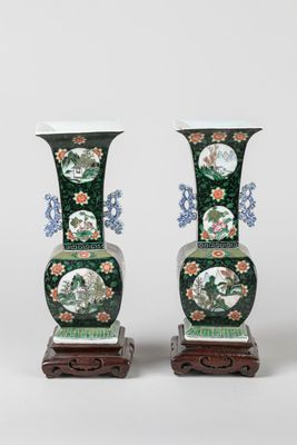pair of green vases with floral designs on stands on a white background