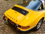 a yellow car parked on a cobblestone road