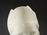 a white statue of a child with a hat on