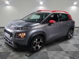 Une Citroën grise est garée dans une pièce au sol carrelé