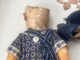 a small doll with a blue shirt and a blue hat