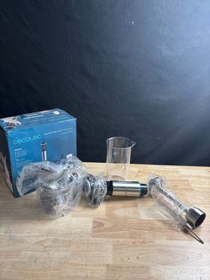 a glass and a syssor sitting on a table next to a box