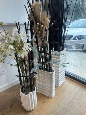 deux vases remplis de fleurs posés sur une table