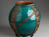 an image of a green vase with a decorative design on it