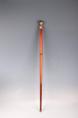 an old wooden baseball bat with a red handle on a white surface
