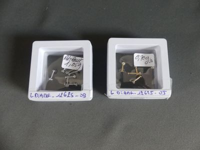 two white boxes with screws in them on a table
