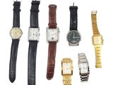 Plusieurs types de montres sont alignées sur une surface blanche
