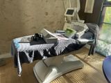 a table with a laptop on it in a room with a window