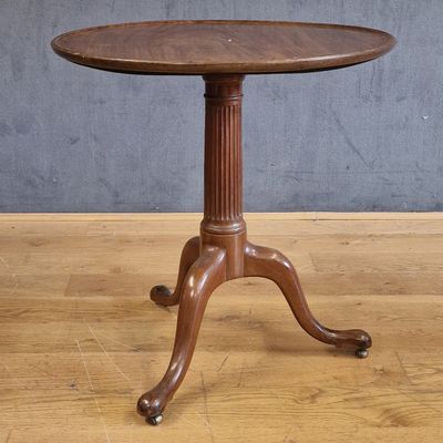 une vieille table en bois avec un plateau en bois, posée sur un parquet