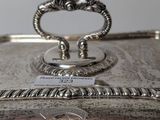an antique silver plate with a handle on top of it