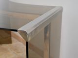 a glass table with a metal base and a glass top