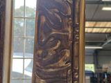 a mirror that has a carved design on it