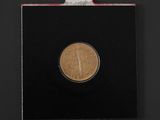 a close up of a coin in a black box on a black surface