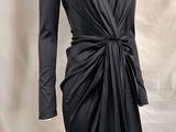 La robe est noire et a des manches longues.