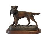 statue of a dog with a pheasant in its mouth on a wooden base