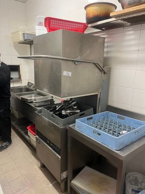 un homme debout dans une cuisine, à côté d'une cuisinière