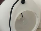 a white lamp that is on a table with a black cord